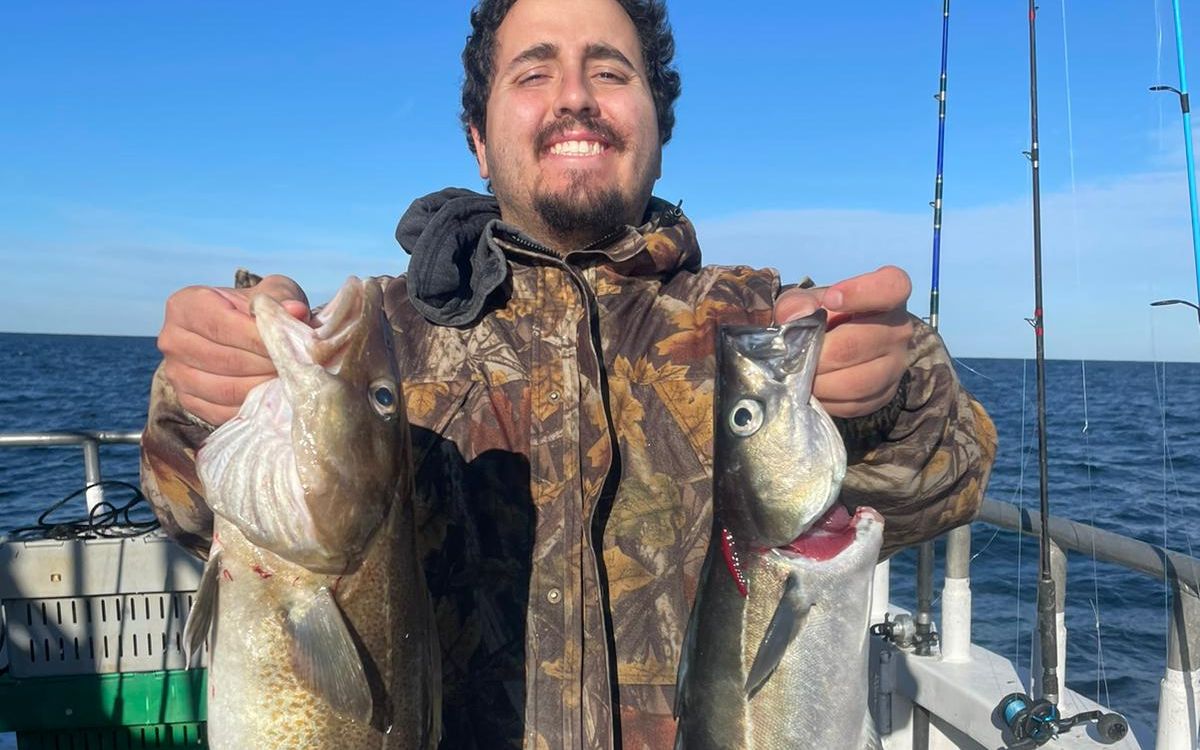Angler holding two fish on deck