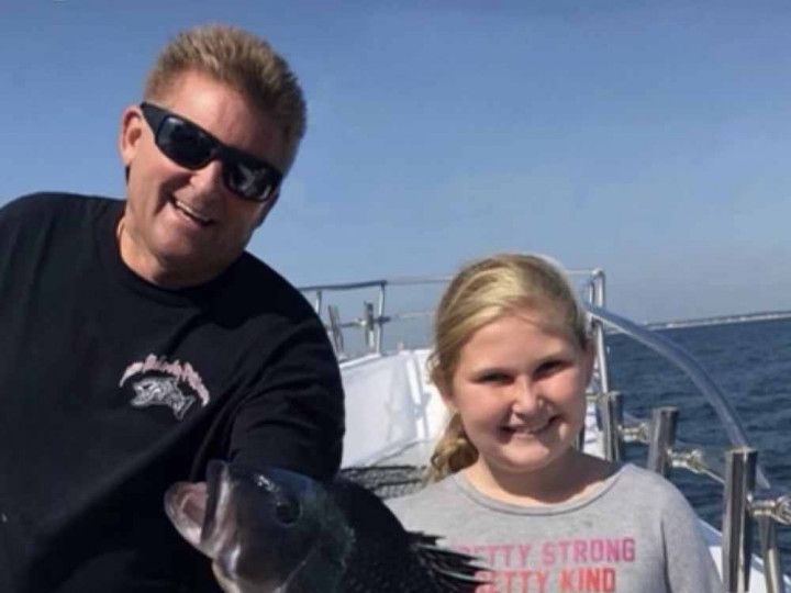 Father and daughter with their catch on a family trip